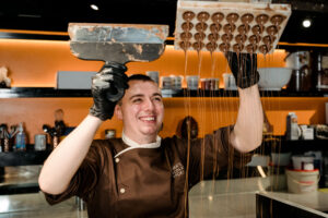 Chocolatier demonstrating chocolate rain technique