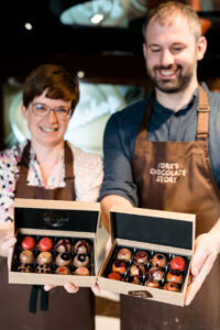 Couple presenting chocolates they made in masterclass